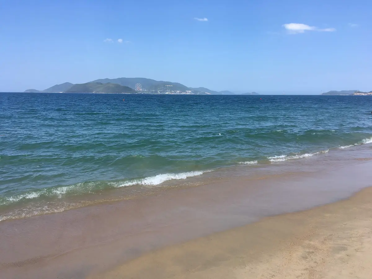 Waves on Nha Trang beach with islands behind